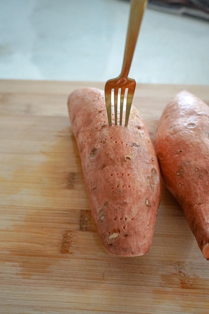 a fork piercing a sweet potato