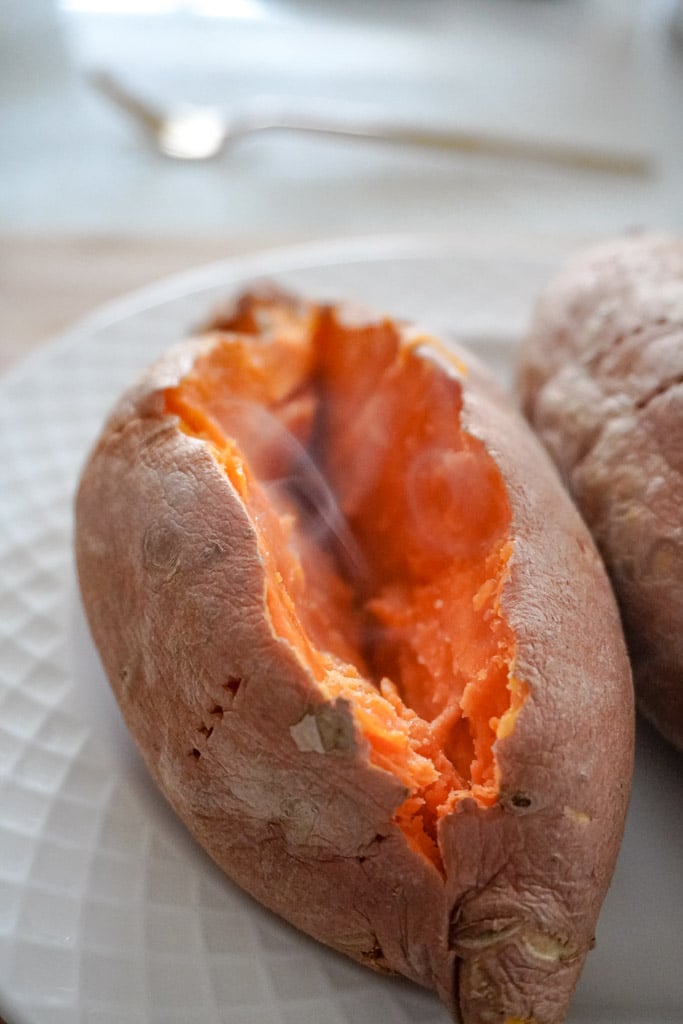 a microwave sweet potato sliced with steam coming out