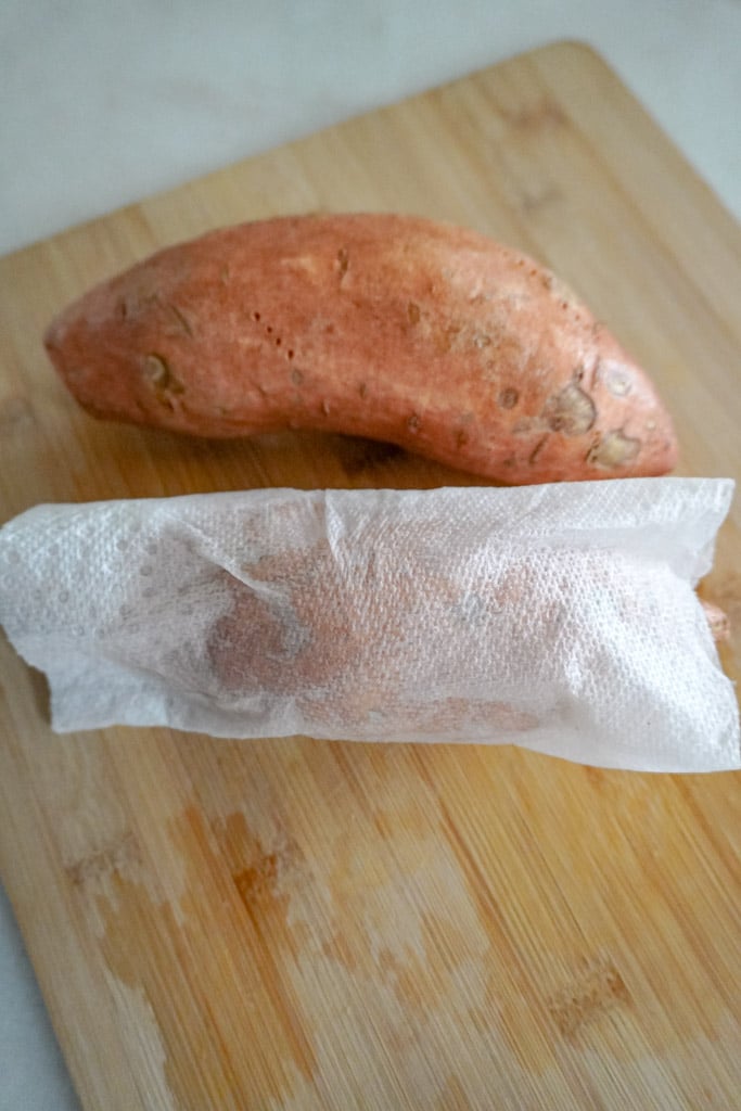 a sweet potato wrapped in a damp paper towel