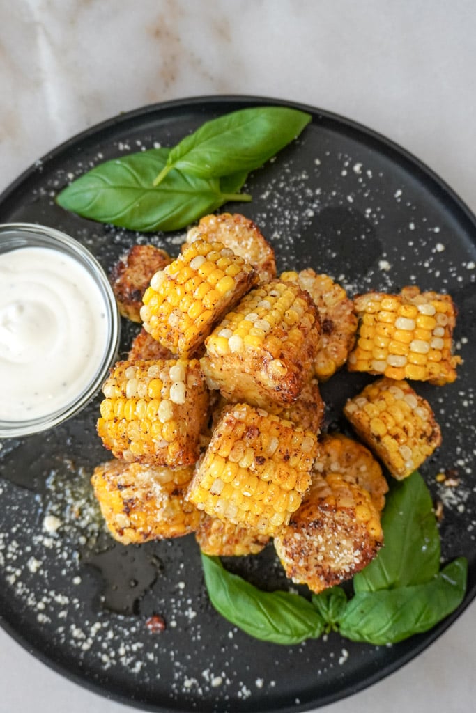 plated cajun fried corn on the cob with a side of ranch dressing