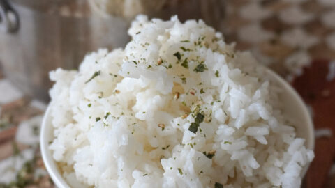 a bowl of white rice beside a pot of more rice