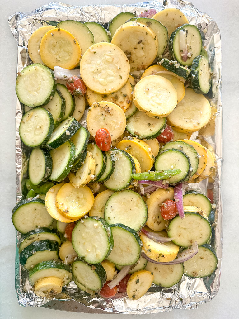 raw, seasoned veggies on a grill tray