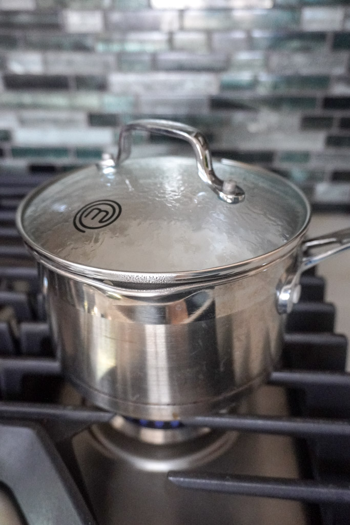 a pot with the lid on cooking white rice