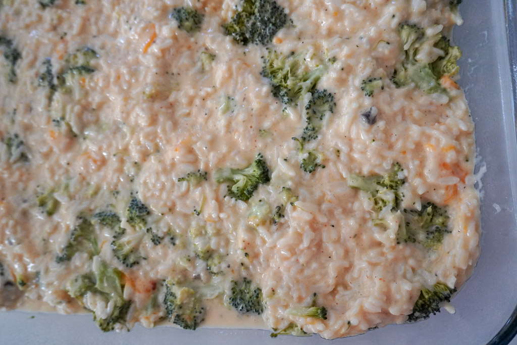 close up view of uncooked broccoli rice casserole in a dish
