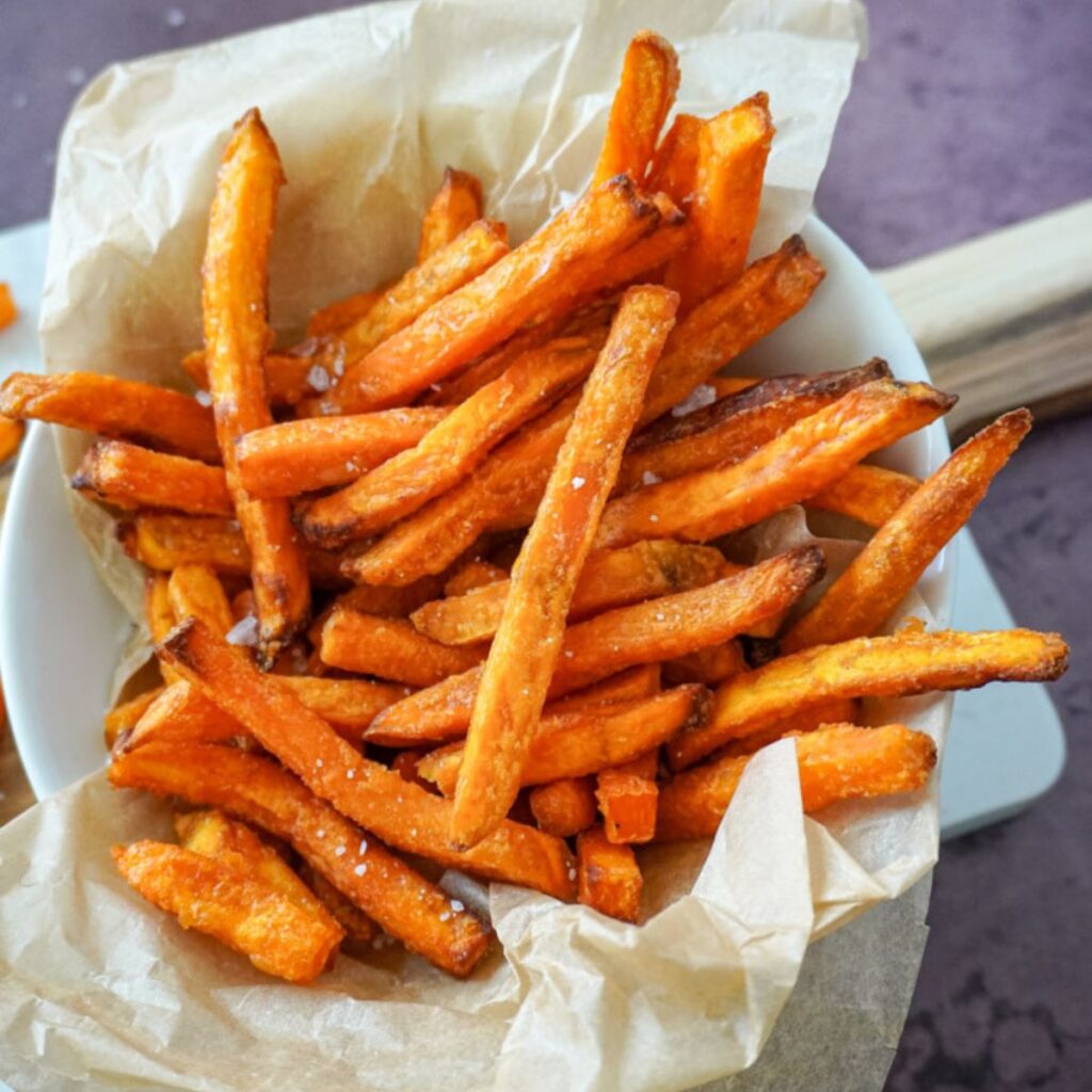 close up view of air fryer sweet potato fries in a basket