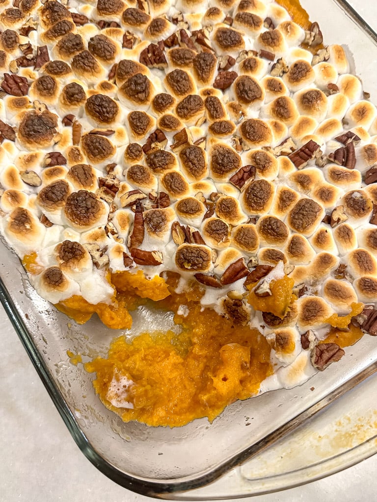 a dish of sweet potato casserole with a scoop taken out