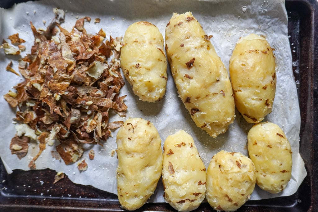 baked potatoes peeled on a cutting board for baked potato salad