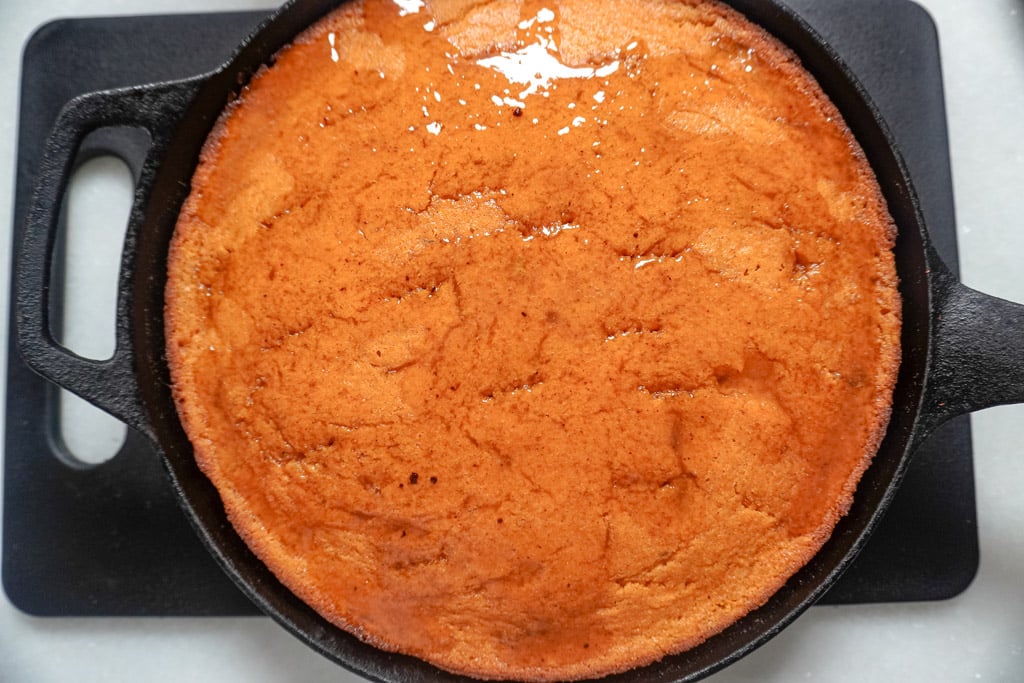 glazed sweet potato cornbread in a cast iron skillet