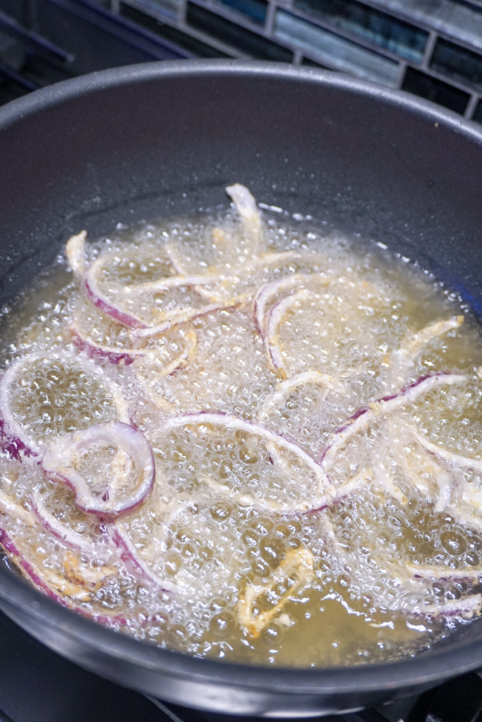 coated onions frying in a skillet
