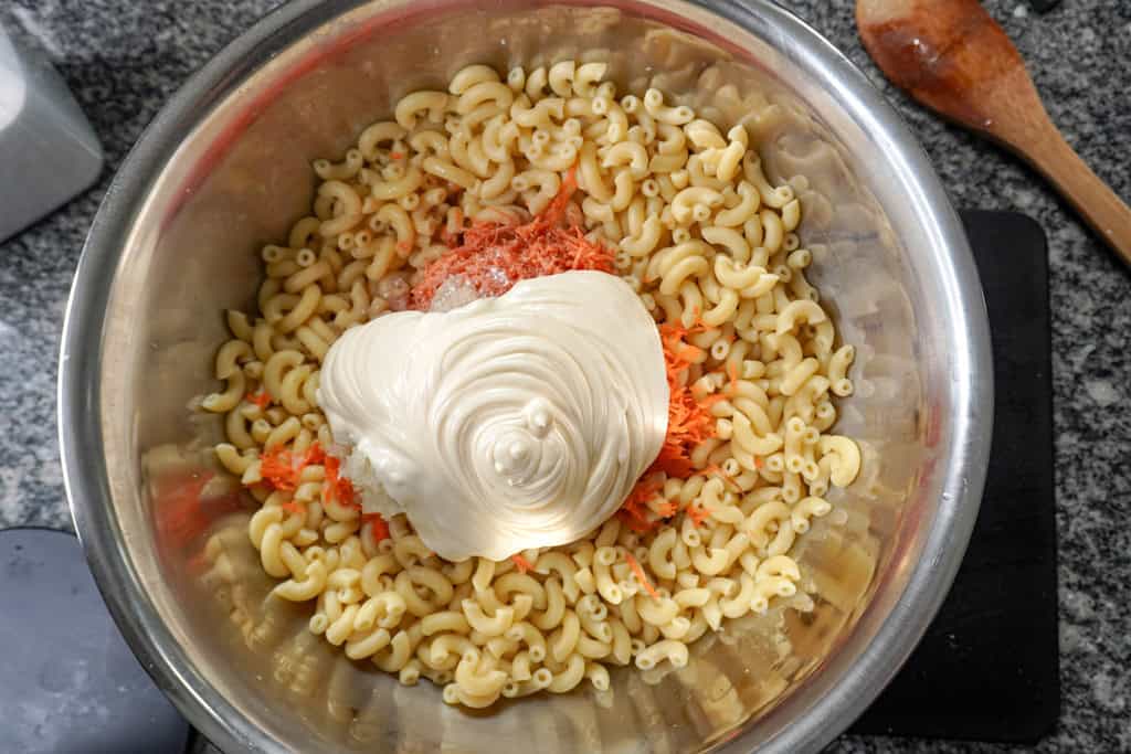 mayo added to a bowl of macaroni