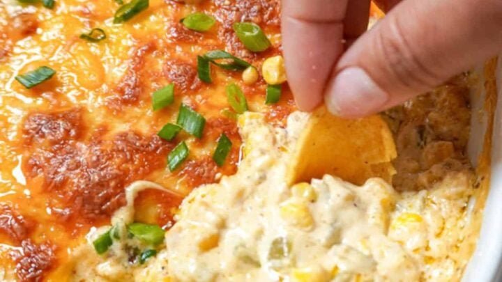 a hand dipping a chip into hot dip