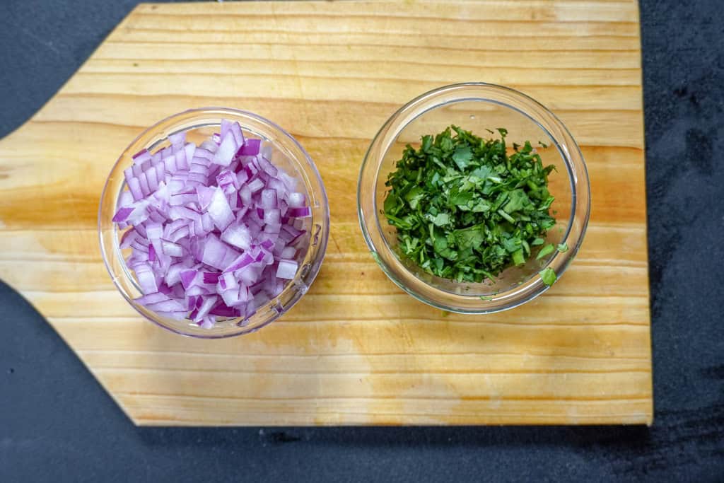 two small bowls containing red onion and cilantro