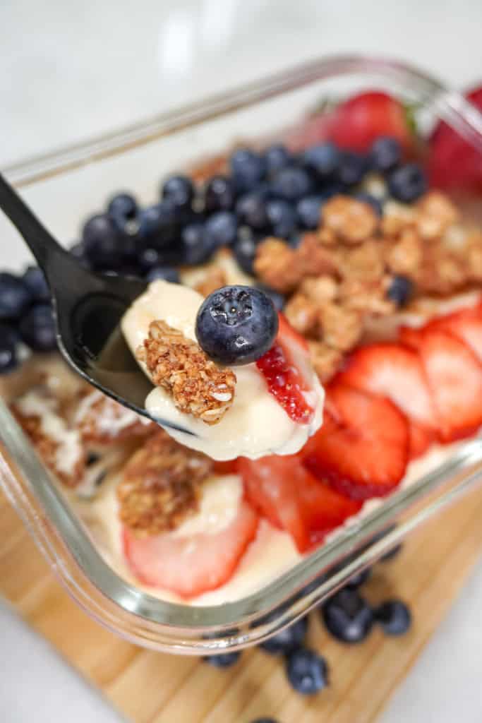 a spoonful of protein pudding hovering over a dish containing more