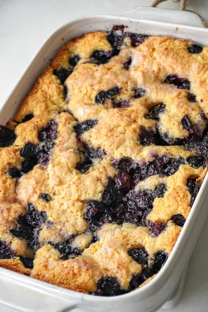 close up view of freshly baked blueberry cobbler in a rectangular dish.