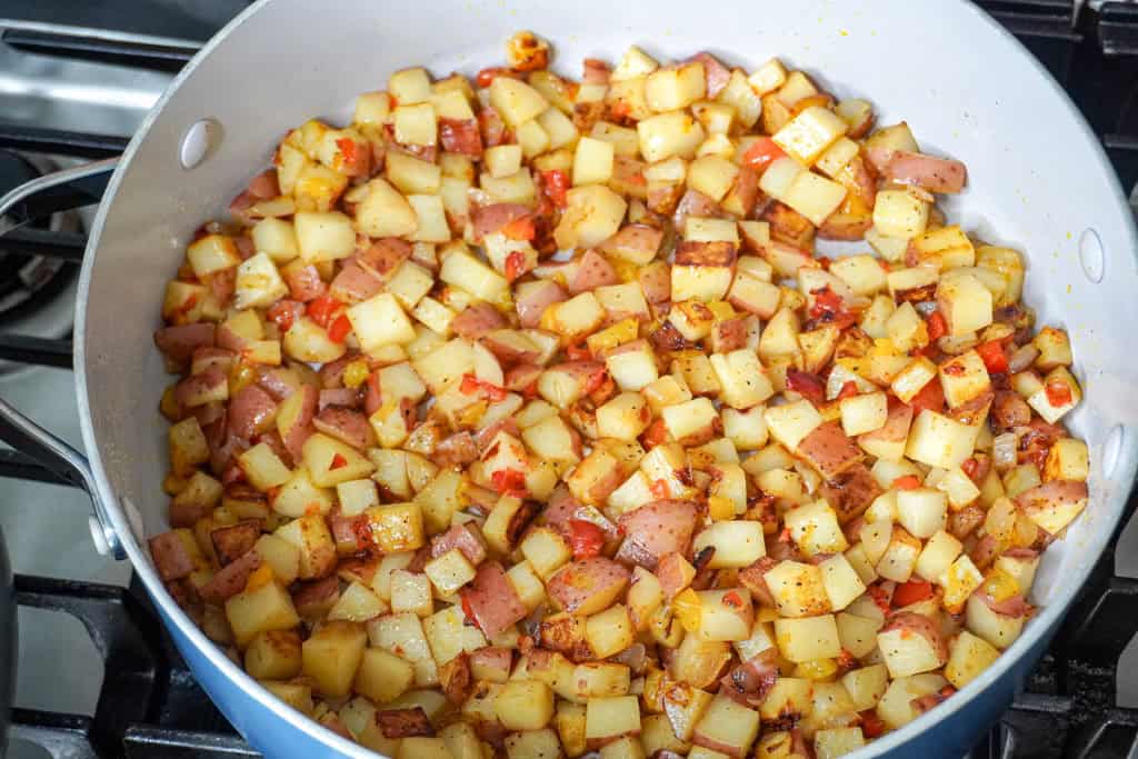 A large skillet filled with cooked obrien potatoes.