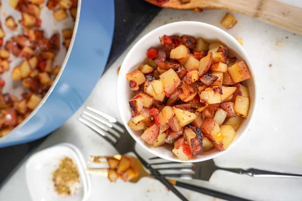 A close-up of Potatoes O'Brien served in a white bowl.