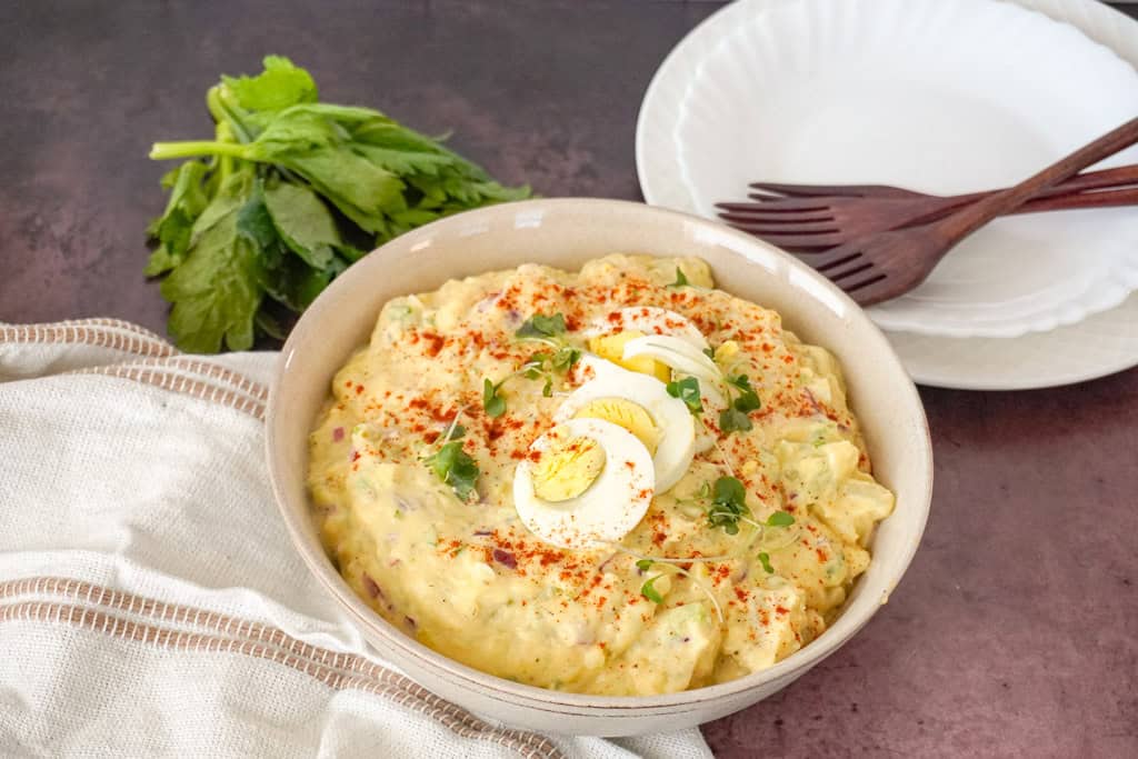 a bowl of southern potato salad garnished with sliced boiled eggs