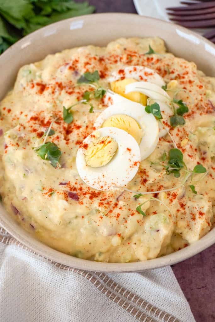 a bowl of southern potato salad garnished with sliced boiled eggs