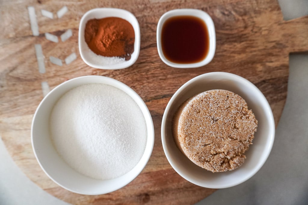 brown sugar, cinnamon, ground cloves, white sugar, and vanilla in bowls for apple butter
