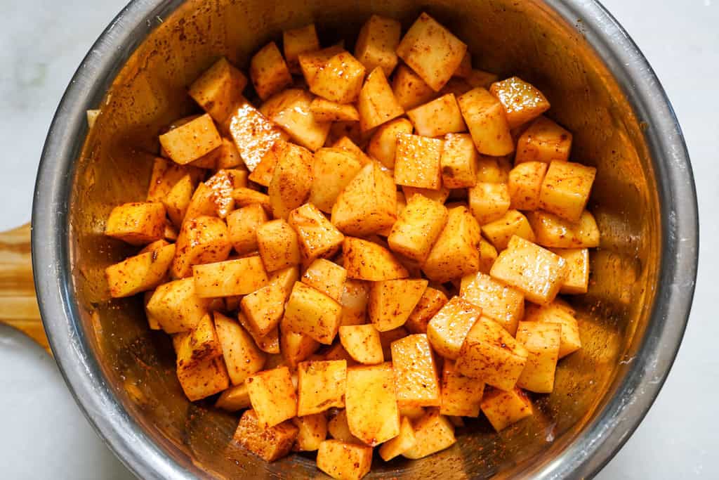 diced potatoes in a bowl with seasoning for fiesta potatoes