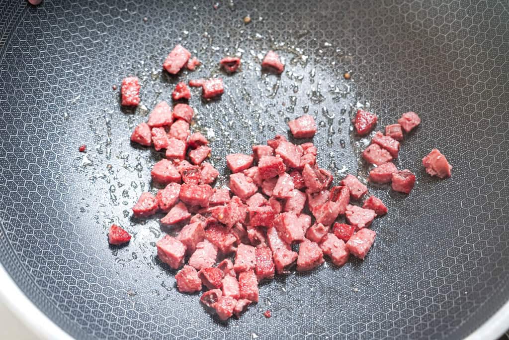 cooking smoked sausage in a skillet for dirty rice
