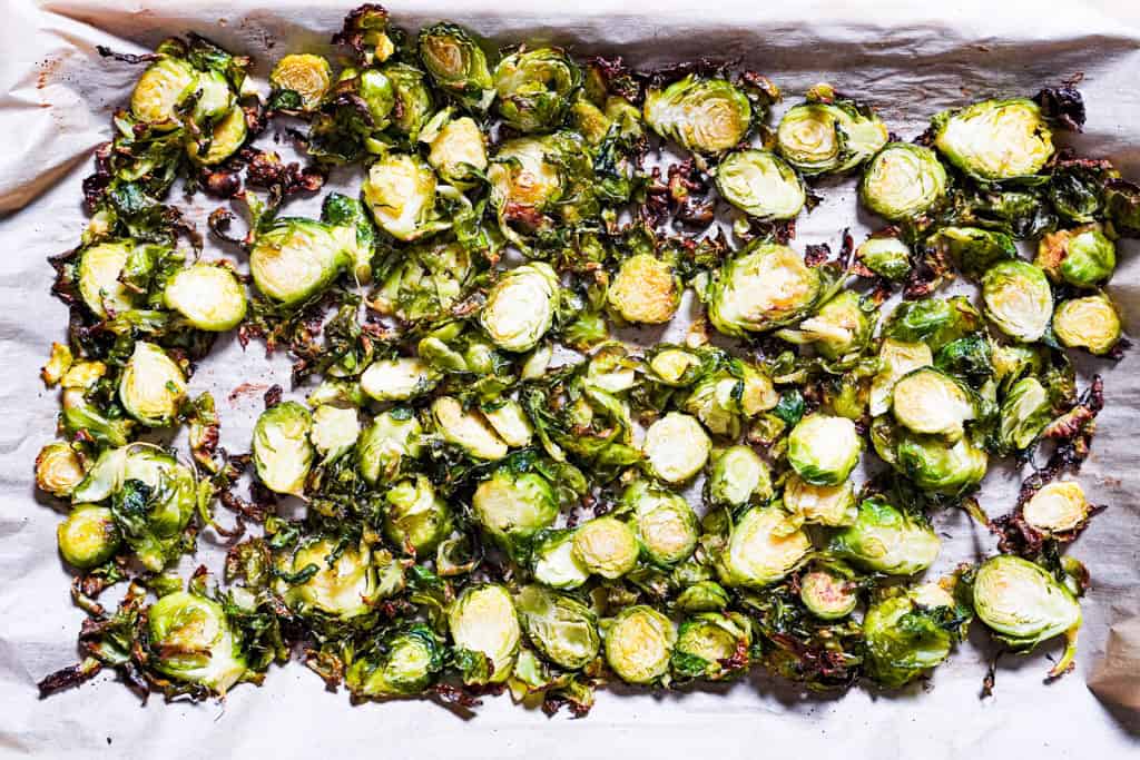 sheet pan with shaved brussel sprouts on parchment paper