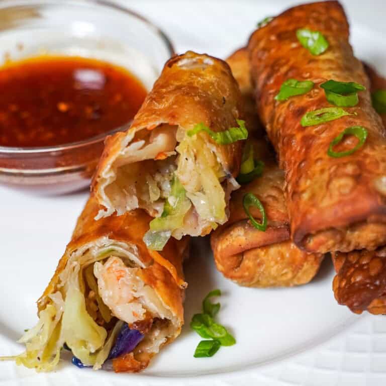 shrimp egg rolls on a plate with sweet and sour sauce