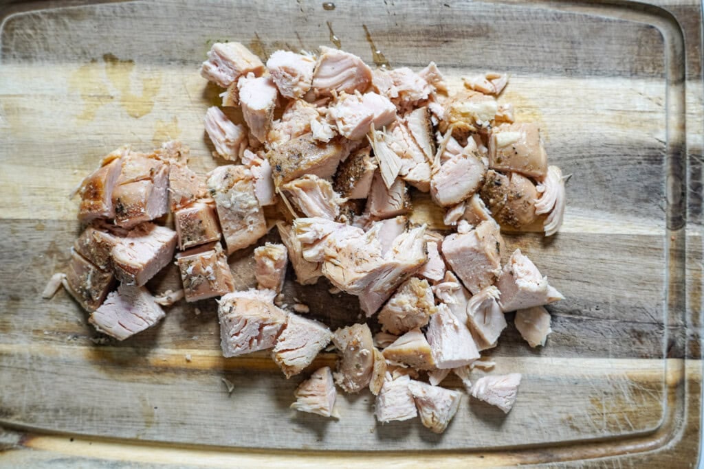 chicken breast diced on a cutting board