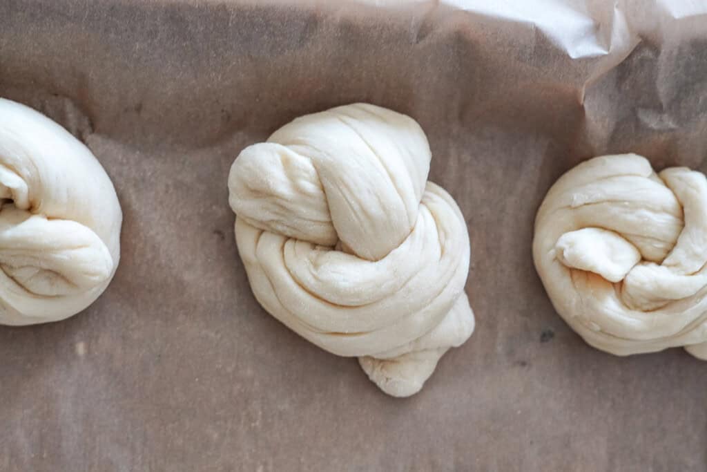 garlic knot resting on a sheet pan